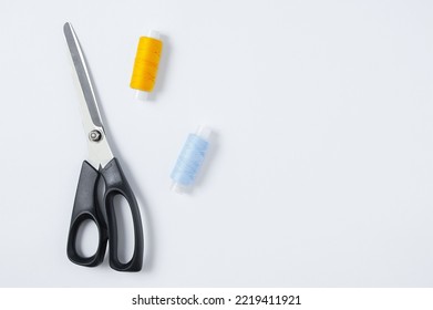 Fabric Scissors And Sewing Thread. White Background. View From Above. Place For Text.