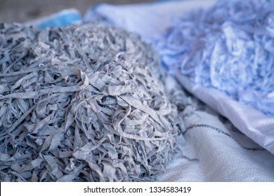 Fabric scraps, old clothing and textiles are cut into strips waiting for recycle.