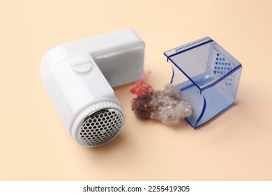 Fabric shaver with fuzz on beige background, closeup. Modern appliance - Shutterstock ID 2255419305