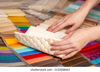 Fabric Swatches In Different Colors Are Stacked For Selection. A Woman Chooses Upholstery Colors For Furniture And Interiors. Touches The Texture Of The Fabric, Hands On The Material Close-up.