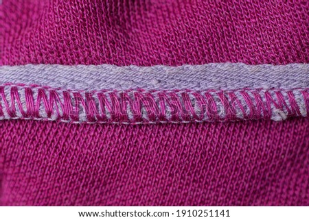 fabric texture of white seam with red threads on woolen clothes