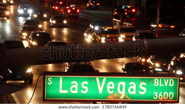 Fabulos Las Vegas, traffic sign glowing on The\
Strip in sin city of USA. Iconic signboard on the road to Fremont\
street in Nevada. Illuminated symbol of casino money playing and\
bets in gaming area.