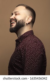 Fabulous At Any Age Concept. Profile Portrait Of Laughing 40-year-old Man Standing Over Beige Background. Modern Haircut. Hipster Style. Close Up. Studio Shot