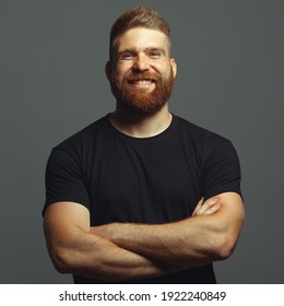 Fabulous at any age. Emotive portrait of laughing charismatic muscular 30-year-old man standing over light gray background. Perfect haircut. Rocker, biker, hipster style. Studio shot
