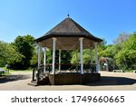 Fabulous  bandstand with no people in public park with deep blue sky background and trees in summer