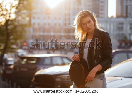 Fabulous blonde woman wearing casual jacket and t shirt posing at sunset. Space for text