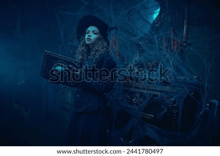 Fabulous Halloween. A young witch sorceress casts a spell with a magic wand. The scenery of an old castle shrouded in cobwebs. Fantasy.