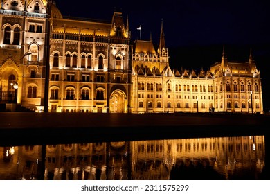 A fabulous nighttime photo of the illuminated facade of the parliament building in Budapest, reflected in the water. Budapest, Hungary - 08.24.2022 - Shutterstock ID 2311575299