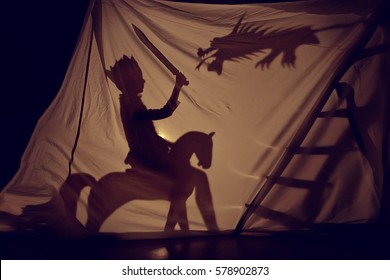 Fabulous the shadow of the little Prince on horse with sword and dragon. Theatre. Childhood. Tale. - Shutterstock ID 578902873