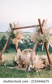 Fabulous wedding for two. Wedding table set up in boho style with pampas grass and greenery, and two straw chair in field with sunset view
