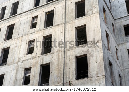 Facade of abandoned construction site of a multi storey building with no windows.