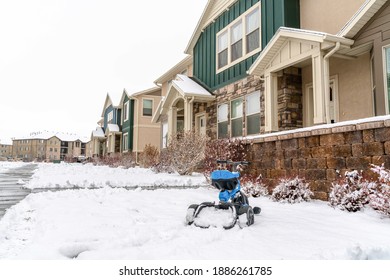 Facade Of Apartment With Three Wheel Bicycle For Kids On The Snow Blanketed Yard