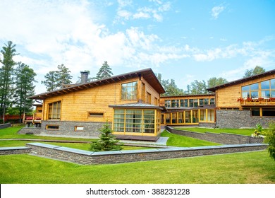 Facade Of A Beautiful Wooden House With Green Garden