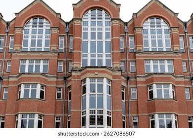 Facade of a brick building featuring multiple windows and symmetrical architectural design elements in Leeds, UK.