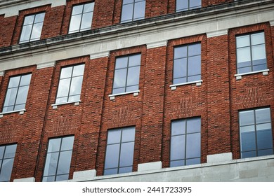 Facade of a brick building with symmetrical windows reflecting the sky, architectural background in Leeds, UK. - Powered by Shutterstock