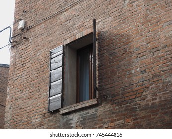 
Facade, brick wall, open window.