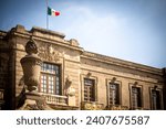 Facade of the castle in the Chapultepec forest from the side with fountain and Mexican flag.