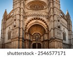 Facade of Catedral de Mallorca in Palma, Mallorca, Spain. Beautiful architecture featuring a historic Cathedral church entrance adorned with intricate carvings and sculptures. Panoramic shot.