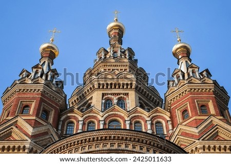 Facade of the Cathedral of Saints Peter and Paul is under blue sky. It is a Russian Orthodox cathedral located in Petergof, Russia. It was designed by Nikolai Sultanov and completed in 1905