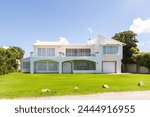 The facade of a colonial - style villa on the shores of the Indian Ocean . A country house on a blue sky background .