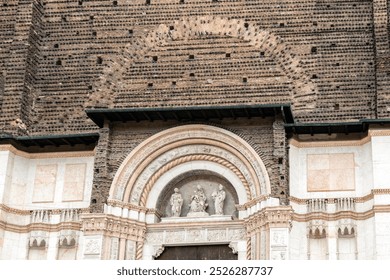 Facade detail of Basilica of San Petronio with red bricks, white marble, and sculptures, Bologna, Italy - Powered by Shutterstock