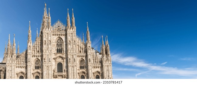Facade of the Duomo di Milano against a clear blue sky with clouds and copy space. (Milan Cathedral 1418-1577). Church, monument symbol of Lombardy, Italy, Europe. - Shutterstock ID 2310781417