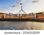 Facade of Federal national parliament house in Canberra capital city of Australia at sunset.