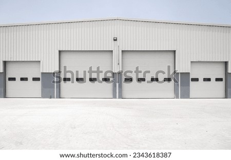 Facade (front view) of a large hangar lined with a metal profile. 
