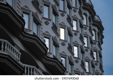 Facade Of A Historical Building In City Center Early In The Morning With One Window Lit By A Room Light.