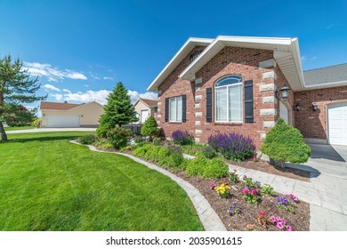 Facade Of A House With Colorful Front Yard Garden And Concrete Walkway