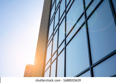 Facade Of Modern Glass Building At Sunset. Warm And Cool Tone Contrast. Sun Flare.