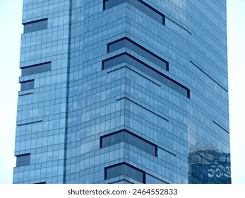 Facade of a modern high-rise building with blue glass windows. - Powered by Shutterstock