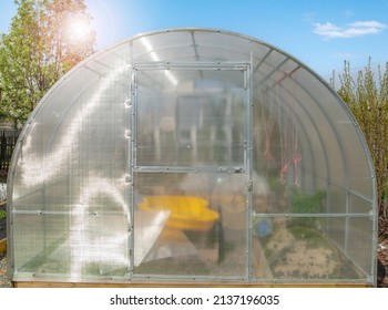 Facade Of A Modern Polycarbonate Greenhouse On A Private Plot Against A Blue Sky, Spring, Outdoors.