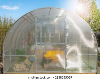 Facade Of A Modern Polycarbonate Greenhouse On A Private Plot Against A Blue Sky, Spring, Outdoors.