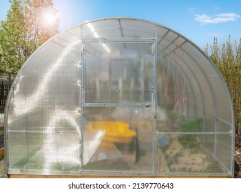 Facade Of A Modern Polycarbonate Greenhouse On A Private Plot Against A Blue Sky, Spring, Outdoors