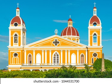 The facade of the neo-classical cathedral in yellow and orange tones at sunset in Granada, Nicaragua, Central America.