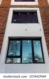 the facade of a new multi storey building under construction with Windows and balconies and insulated walls