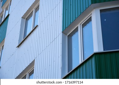facade of a new multi-storey building with white and green metal siding, many Windows - Shutterstock ID 1716397114