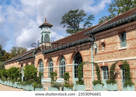 Facade of an old Greenhouse at the Jardin des Serres d'Auteuil in summer. This botanical gaden is a public park located in Paris, France
