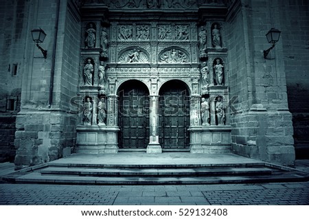 Facade of old medieval church, detail of a wooden door and gothic sculptures, City Tours
