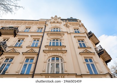 Facade of old tenement house, residential building with balconies and decorative windows. Low angle view of renovated block of flats