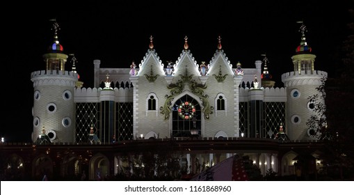facade of a puppet theater with a clock on the background of a black sky