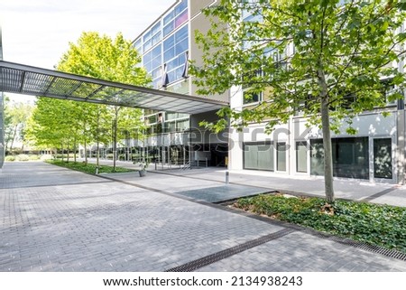 Facade of a residential building with a front with a glass surface and a garden with trees in an interior passage
