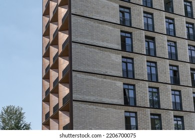 The facade of a residential complex made up of two textures , copper and brick . Modern architecture . Elements of a architecture .