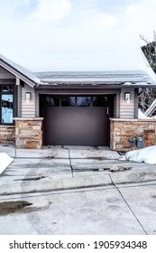 Facade Of A Residential Single Car Garage Attached To A House Against Cloudy Sky