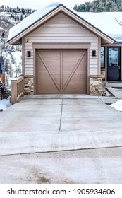 Facade Of Residential Single Car Garage Against Snowy Mountain Landscape In Utah