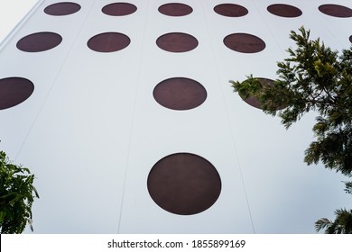 Facade seen from below of the circular windows of a smooth steel wall.