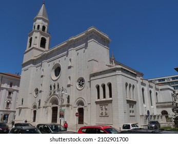 facade of St. Cetteo cathedral in Pescara made of white stone with three entrance portals surmounted by rose windows and flanked by the bell tower and the baptistery - Shutterstock ID 2102901700