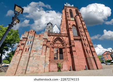 The facade and the steeple of the cathedral in Wetzlar, "Dom unserer lieben Frau" from the frog perspective in sunny weather and blue sky with fair weather clouds