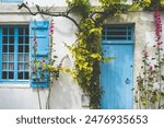 Facade of a stone house with blue shutters in Talmont-sur-Gironde